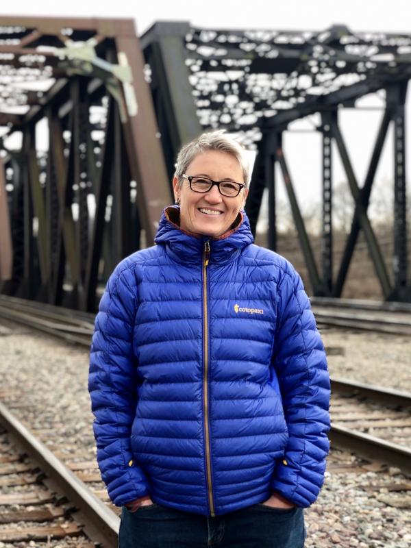 Julia Applegate standing in front of a railroad tress in winter